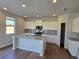 Modern kitchen with white cabinets, granite countertops, and stainless steel appliances at 2371 Brown Dove Way Lot 4, Grayson, GA 30017