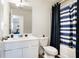 Bathroom with a white vanity, toilet, tub, and blue/white striped shower curtain at 579 Magnolia Cir, Palmetto, GA 30268