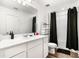 Modern bathroom with a large mirror, white cabinets, and black shower curtain at 579 Magnolia Cir, Palmetto, GA 30268