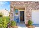 Inviting front entry with a welcome sign, brick facade, and manicured landscaping at 579 Magnolia Cir, Palmetto, GA 30268