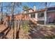 Back of the house with the back deck and stairs down to the yard covered in pine needles at 1865 Berkeley Mews Ne, Atlanta, GA 30329