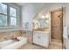 Bathroom features a walk-in shower, soaking tub, decorative tile, and a window at 1865 Berkeley Mews Ne, Atlanta, GA 30329