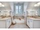 Well-lit bathroom features dual vanity, soaking tub, decorative tile, and a window at 1865 Berkeley Mews Ne, Atlanta, GA 30329