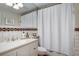 White bathroom features decorative tile, vanity, sink, and a shower-tub combination at 1865 Berkeley Mews Ne, Atlanta, GA 30329