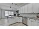 This kitchen features gray countertops, stainless appliances, white cabinets, and wood floors at 2860 Chardonnay Ln, Cumming, GA 30041