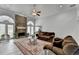 Open living room with stone fireplace, large windows, ceiling fan, and hardwood floors at 2860 Chardonnay Ln, Cumming, GA 30041