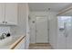 Bright mud room area with a utility sink and storage cabinet, along with a white refrigerator at 2860 Chardonnay Ln, Cumming, GA 30041