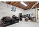 Unfinished basement area with exposed wooden ceiling, white-painted brick walls, and a small window for natural light at 3154 Chamblee Tucker Rd, Atlanta, GA 30341