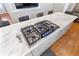 Kitchen island featuring cooktop with stainless steel appliances and white marble countertop at 3154 Chamblee Tucker Rd, Atlanta, GA 30341