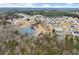 This aerial view showcases the community with mature trees and a tranquil pond at 6124 Locklear Way, Douglasville, GA 30134