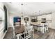 Bright kitchen featuring a dining table, white cabinetry, an island with barstool seating, and stainless appliances at 6124 Locklear Way, Douglasville, GA 30134