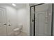 Bright bathroom featuring a stand-up shower with black trim, toilet, and tile flooring at 6515 Bentley Ridge Dr, Cumming, GA 30040