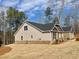 Side view of a beige home on a gently sloping lot, showing the architectural details and landscaping at 3392 Milan Ct, Douglasville, GA 30135