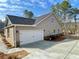 A home with a two-car garage and a concrete driveway set against a backdrop of trees and sky at 3392 Milan Ct, Douglasville, GA 30135