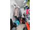 Walk-in closet with metal shelving, hanging clothes, various storage containers, and personal items at 40 Berkshire Run, Covington, GA 30016