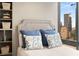 Close-up of a bedroom with a patterned comforter, decorative pillows, built-in shelving, and city views at 145 15Th Ne St # 1430, Atlanta, GA 30309