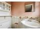 A close-up of a bathroom sink and toilet with vintage fixtures and a pink wall at 1523 Delia Dr, Decatur, GA 30033