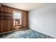 View of a bedroom with a wood-paneled accent wall, a window with shutters, and blue carpet at 1523 Delia Dr, Decatur, GA 30033