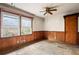 A room with wood paneled walling, windows, ceiling fan and door, ready for renovation at 1523 Delia Dr, Decatur, GA 30033