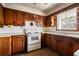 Vintage kitchen featuring wood cabinets and a white countertop and appliances near the window at 1523 Delia Dr, Decatur, GA 30033