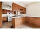 A view of a vintage kitchen with light-colored countertops, outdated cabinets, and a white stove at 1523 Delia Dr, Decatur, GA 30033