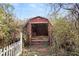 Shed with an open door surrounded by bushes and a white picket fence at 1523 Delia Dr, Decatur, GA 30033