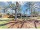 Serene landscape with mature trees frames this charming brick home with well-kept grass and natural pine straw accents at 2187 Freydale Se Rd, Marietta, GA 30067