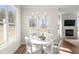 Bright dining area with white table and chairs, large windows, and fireplace in the background at 4170 Cavalier Way, Duluth, GA 30097