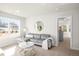 Sunlit living room with plush sofa, round mirror, and a view to a doorway at 4170 Cavalier Way, Duluth, GA 30097