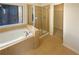 Bright bathroom featuring a soaking tub and separate glass shower at 4556 Creekside Cv, Atlanta, GA 30349