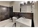 A stylish bathroom featuring tiled walls, vanity with a sink and a standard toilet at 1848 Englewood Way, Snellville, GA 30078