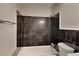 An elegant bathroom featuring tiled walls, a standard tub and a standard toilet at 1848 Englewood Way, Snellville, GA 30078