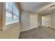 Bright bedroom featuring a large window with blinds, neutral walls, carpet flooring, and closet space at 1848 Englewood Way, Snellville, GA 30078