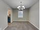 Cozy dining room with carpet flooring, a classic chandelier, and a view into the adjacent kitchen at 1848 Englewood Way, Snellville, GA 30078