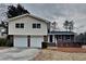 Split-level home featuring brick and siding, an attached two-car garage, and a well-maintained front yard on an overcast day at 1848 Englewood Way, Snellville, GA 30078