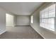 Bright living room with neutral paint, carpet flooring, and large windows offering plenty of natural light at 1848 Englewood Way, Snellville, GA 30078