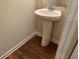 Bathroom with a pedestal sink, mirror and wood-style flooring at 7467 Saint David St, Fairburn, GA 30213