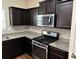 Kitchen features stainless appliances, granite countertops, and dark wood cabinetry at 7467 Saint David St, Fairburn, GA 30213