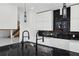 Close-up view of the kitchen island with a stainless-steel sink, black marble countertop and backsplash with white cabinets at 1410 Lavista Ne Rd, Atlanta, GA 30324