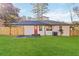 A wide backyard with a red door on a white brick house at 1796 Arkose Se Dr, Atlanta, GA 30316