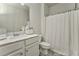 Cozy bathroom showcasing a single sink vanity with a marble countertop and a shower with a white curtain at 530 Vandenburg Dr, Villa Rica, GA 30180