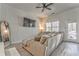 Comfortable living room with modern decor, a large sectional sofa, a ceiling fan, and natural light from a large window at 530 Vandenburg Dr, Villa Rica, GA 30180