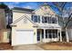 Charming two-story home with a covered porch, attached garage, and landscaped front yard at 65 Devonshire Dr, Alpharetta, GA 30022