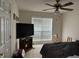 Bedroom with ceiling fan, large window with blinds, and a television on a console at 2690 Freemans Walk Dr, Dacula, GA 30019