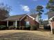 Exterior elevation of the home showing brick facade, manicured landscaping and mature trees at 2690 Freemans Walk Dr, Dacula, GA 30019