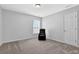 Cozy bedroom with neutral walls, plush carpeting and a black gaming chair near a bright window at 4002 Forest Grove Nw Pass, Acworth, GA 30101