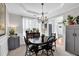Formal dining room with a black table, chandelier, and large window with sheer curtains, creating a warm atmosphere at 4002 Forest Grove Nw Pass, Acworth, GA 30101