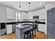 Modern kitchen featuring white cabinets, stainless steel appliances, black countertops, and a kitchen island with barstool seating at 4002 Forest Grove Nw Pass, Acworth, GA 30101