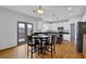 Bright kitchen with stainless steel appliances, white cabinets, island with barstools, and a breakfast table with french doors at 4002 Forest Grove Nw Pass, Acworth, GA 30101