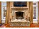 Stone fireplace is flanked by windows with curtains and sits atop hardwood floors at 4266 Woodland Brook Se Dr, Atlanta, GA 30339